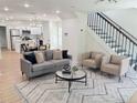 Open-concept living room boasts hardwood floors, a staircase and seamless flow to the dining and kitchen area at 2442 Connally Dr, East Point, GA 30344