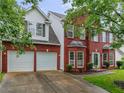 Charming two-story red brick home with a manicured lawn and a two-car garage at 1185 Charter Club Dr, Lawrenceville, GA 30043