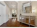 Elegant foyer with hardwood floors, designer mirror, and arched doorway to the spacious living area at 1307 Clarecastle Ln, Buford, GA 30519