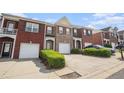 View of several brick townhomes with driveways and manicured lawns at 2279 Hawks Bluff Trl, Lawrenceville, GA 30044