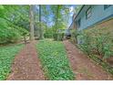 Well-maintained backyard featuring a brick chimney, green groundcover, and access to upper level deck at 4856 Rock Haven Dr, Lilburn, GA 30047