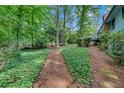 Landscaped backyard with path leading to a deck surrounded by lush greenery at 4856 Rock Haven Dr, Lilburn, GA 30047