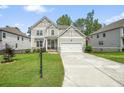 Charming two-story home with a two-car garage, manicured lawn, and stone accents at 6915 Rambling Vale, Cumming, GA 30028