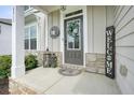 Inviting front porch with decorative accents, a welcome sign, and stone accents at 6915 Rambling Vale, Cumming, GA 30028