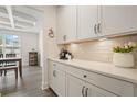 Bright kitchen featuring white cabinets, quartz countertops, subway tile backsplash, and stylish decor, creating a modern culinary space at 6915 Rambling Vale, Cumming, GA 30028
