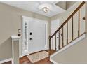 Bright entryway featuring hardwood floors, a staircase with wooden banister, and a white front door at 2640 Garland Way, Duluth, GA 30096