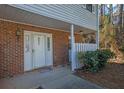 A close-up of the front door with brick facade, a white picket fence, and a well-maintained exterior at 6027 Wintergreen Rd, Norcross, GA 30093