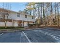 Charming two-story townhouse with neutral siding, brick accents, and a convenient parking area for residents and visitors at 6027 Wintergreen Rd, Norcross, GA 30093