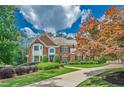 Beautiful brick home with mature trees, lush landscaping, and a curved driveway at 9810 Foxworth Dr, Alpharetta, GA 30022