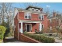 Two-story brick home showcasing a covered front porch, well-maintained landscaping, and private driveway at 1241 Briarcliff Ne Rd, Atlanta, GA 30306