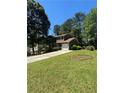 Two-story home with green siding, white garage door, and lush green lawn at 5250 Mountain Village Ct, Stone Mountain, GA 30083