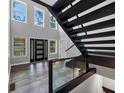 Bright foyer with soaring ceilings, modern staircase, wood floors and black-framed entry door at 212 Lake Forest Dr, Acworth, GA 30102