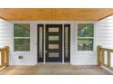 Front door with sidelights, wood deck, and white siding creates a welcoming entrance at 212 Lake Forest Dr, Acworth, GA 30102