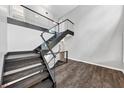Modern floating staircase with glass railing and wood flooring in open living space at 212 Lake Forest Dr, Acworth, GA 30102