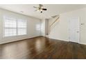 Bright living room boasts hardwood floors, a staircase, a ceiling fan, and access to the front entrance at 4100 Howell Park Rd, Duluth, GA 30096