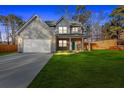 Charming two-story home featuring gray siding, a brick-accented porch, and a two-car garage at 4806 Forest Trl, Douglasville, GA 30135