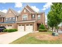 Traditional brick home featuring a two-car garage, partial lawn, and well-kept landscaping at 1957 Brightleaf Way # 59, Marietta, GA 30060