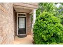 Close up of entryway with black front door, sidelight, and lush green bush at 1957 Brightleaf Way # 59, Marietta, GA 30060