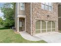 Beautiful stone facade house with a two car garage, green door, and small yard at 4023 Caitlyn Pl, Atlanta, GA 30360