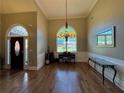 Open-concept living room with grand window, chandelier, and hardwood floors at 4530 Bogan Gates Dr, Buford, GA 30519