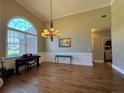 Bright living room boasts natural light from large windows, complementing hardwood floors and elegant chandelier at 4530 Bogan Gates Dr, Buford, GA 30519