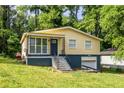 Cozy home featuring a charming porch with metal railings and a well-maintained lawn surrounded by lush trees at 110 Turman Se Ave, Atlanta, GA 30315