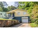 View of the charming yellow single-Gathering home with a single-car garage and driveway at 110 Turman Se Ave, Atlanta, GA 30315