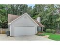 Exterior view highlighting the two-car garage, siding, and mature trees surrounding the property at 169 Parkside Dr, Stockbridge, GA 30281