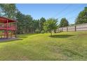 Spacious backyard featuring a lush green lawn, mature trees, and a deck perfect for outdoor entertaining at 3363 Linton Ln, Marietta, GA 30066