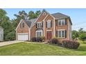 Charming two-story brick home featuring an attached garage, landscaped front yard, and a welcoming red front door at 3363 Linton Ln, Marietta, GA 30066