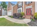 Charming two-story brick home featuring an attached garage, landscaped front yard, and a welcoming red front door at 3363 Linton Ln, Marietta, GA 30066