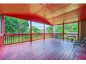 Relaxing red covered porch featuring seating and outdoor grill overlooking the lush green lawn at 3363 Linton Ln, Marietta, GA 30066