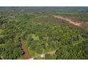 Aerial view featuring dense tree coverage with a body of water, road and cleared area near the tree line at 2520 Hollonville, Brooks, GA 30205