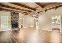 Inviting living room with exposed wood beam ceiling, hardwood floors, and brick fireplace at 2648 Woodacres Ne Rd, Atlanta, GA 30345