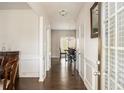Hallway with wood floors, wainscoting, and view into a dining room with hardwood floors at 3013 Nicholas Dr, Villa Rica, GA 30180