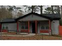 A well-maintained gray house with orange pillars and accent, enclosed by a black chain-link fence at 3479 Thompson Nw Dr, Atlanta, GA 30331