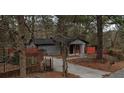 View of a gray single-story home with a tree-lined front yard and a brick mailbox at 3479 Thompson Nw Dr, Atlanta, GA 30331