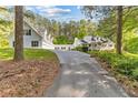 Scenic view of the white home with lush greenery and tall trees at 1981 Luke Edwards Rd, Dacula, GA 30019