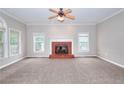 Spacious living room with a cozy brick fireplace, large windows, and neutral carpeting at 931 Bonaventure Way, Lawrenceville, GA 30044