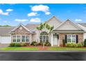 Inviting home exterior featuring stone details, a well-kept lawn, and a covered entrance at 226 Hames Rd # 335, Woodstock, GA 30188