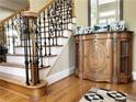 Elegant staircase with black iron railing, hardwood floors, and a decorative cabinet at 608 Tabbystone Nw St, Marietta, GA 30064