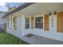 Close up of the front entrance featuring white brick and wooden shutters for windows and stylish lanterns at 1452 Mercer Ave, Atlanta, GA 30337