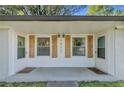 A covered front entry featuring white walls, wood shutters, and a welcome mat at 1452 Mercer Ave, Atlanta, GA 30337