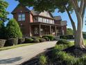 Stately brick home with inviting front porch, lush landscaping, and a curved walkway at 692 Heritage Post Ln, Grayson, GA 30017
