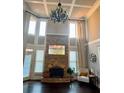 Grand living room featuring a stone fireplace, tall windows, and hardwood floors at 692 Heritage Post Ln, Grayson, GA 30017