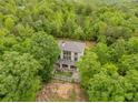 A rear view of the home surrounded by dense foliage showing a multi-story rear deck or patio at 7 Perkins Mountain Rd, Kingston, GA 30145