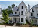 Charming exterior showcasing a two-story white home with a covered porch and elegant architectural details at 11530 Serenbe Ln, Chattahoochee Hills, GA 30268