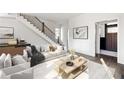 Inviting living room showcasing hardwood floors, contemporary furnishings, and a staircase with iron railing at 11530 Serenbe Ln, Chattahoochee Hills, GA 30268