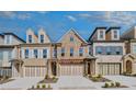 Attractive townhome exteriors featuring brick and stone with well-manicured landscaping at 116 Via Roma, Woodstock, GA 30188