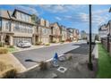 View of the street showcasing beautiful townhome exteriors, manicured lawns, and neighborhood at 116 Via Roma, Woodstock, GA 30188